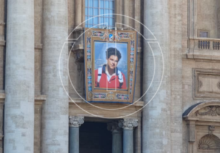 Canonizzazione Carlo Acutis, a San Pietro esposto il drappo | Ad Assisi svelata la statua | Foto – video